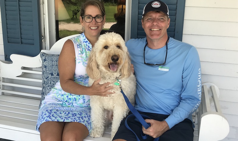 Couple posing with their dog on the front porch of our Dog Friendly Inn