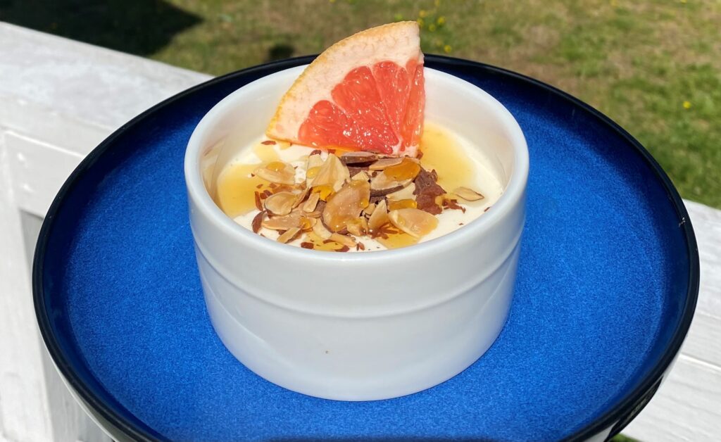 Grapefruit Panna Cotta, garnished with toasted almonds and drizzled with honey.