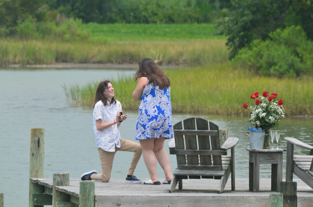 Couple getting engaged at the end of our dock.