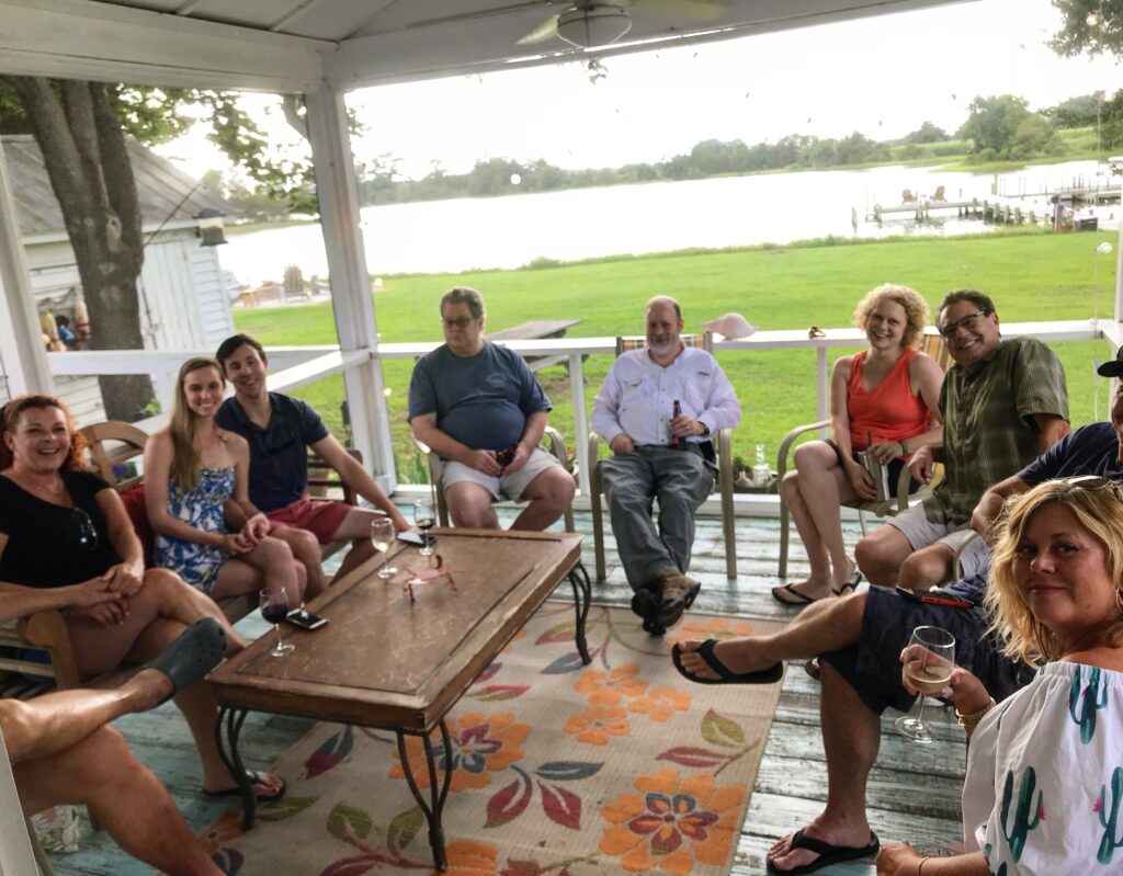 guests hanging in screened in porch during happy hour.