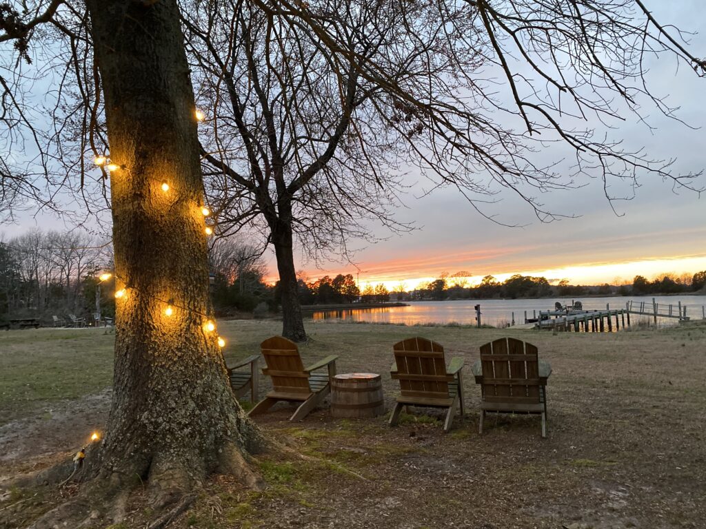 Adirondack chairs overloooking dock and sunset