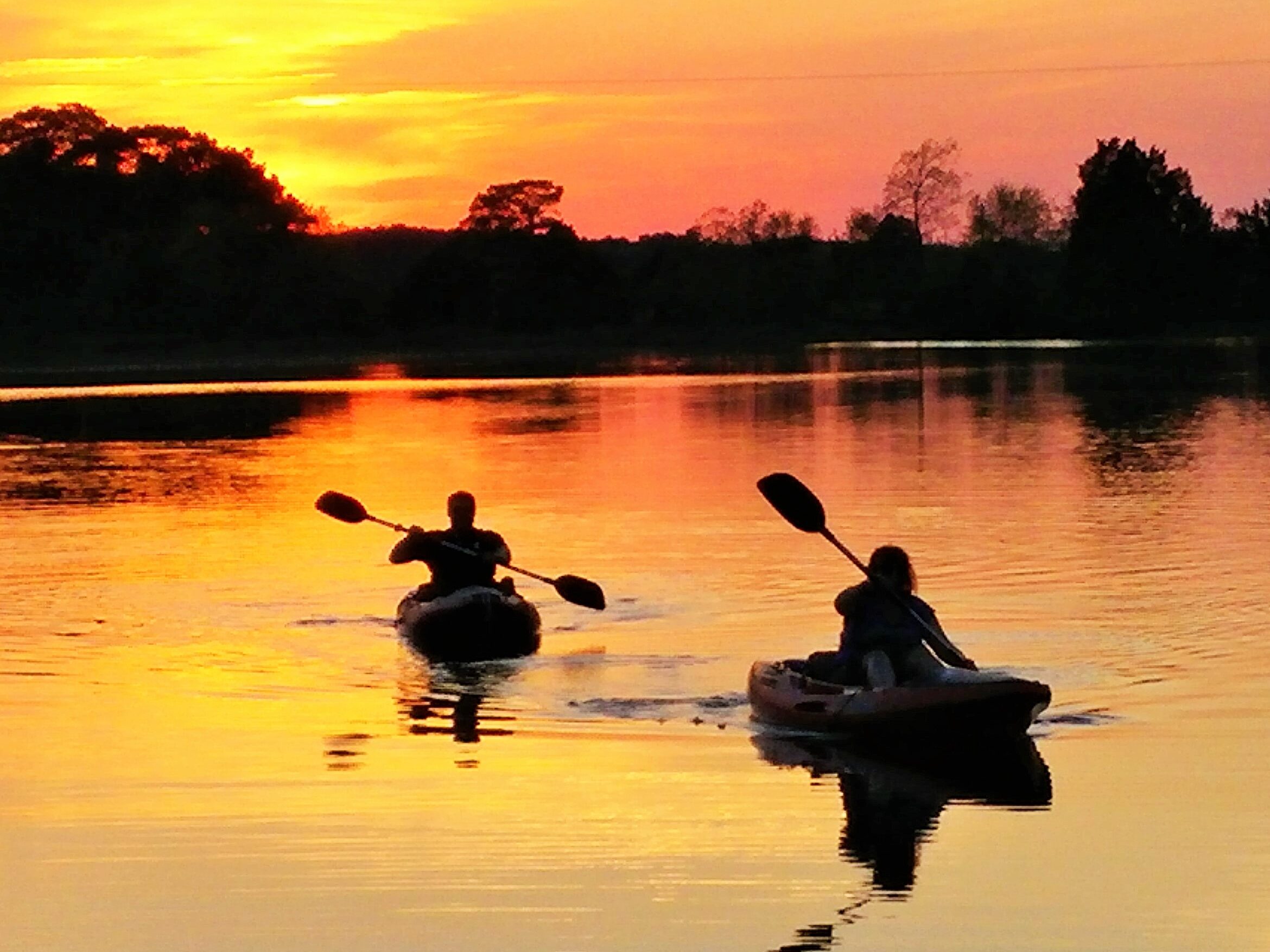 Kayakers finishing their paddle just as the sun finishes setting.