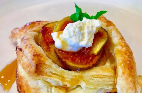 Close up view of a fruit stuffed pastry drizzled with honey