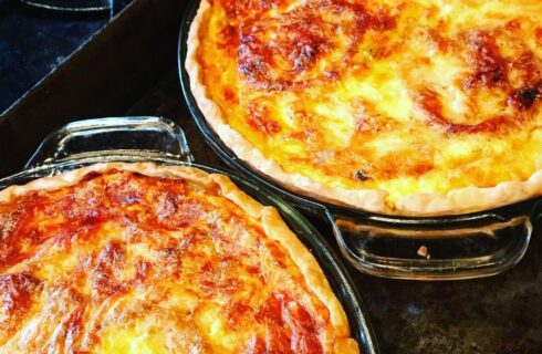 Close up view of two baked quiches in glass pie plates