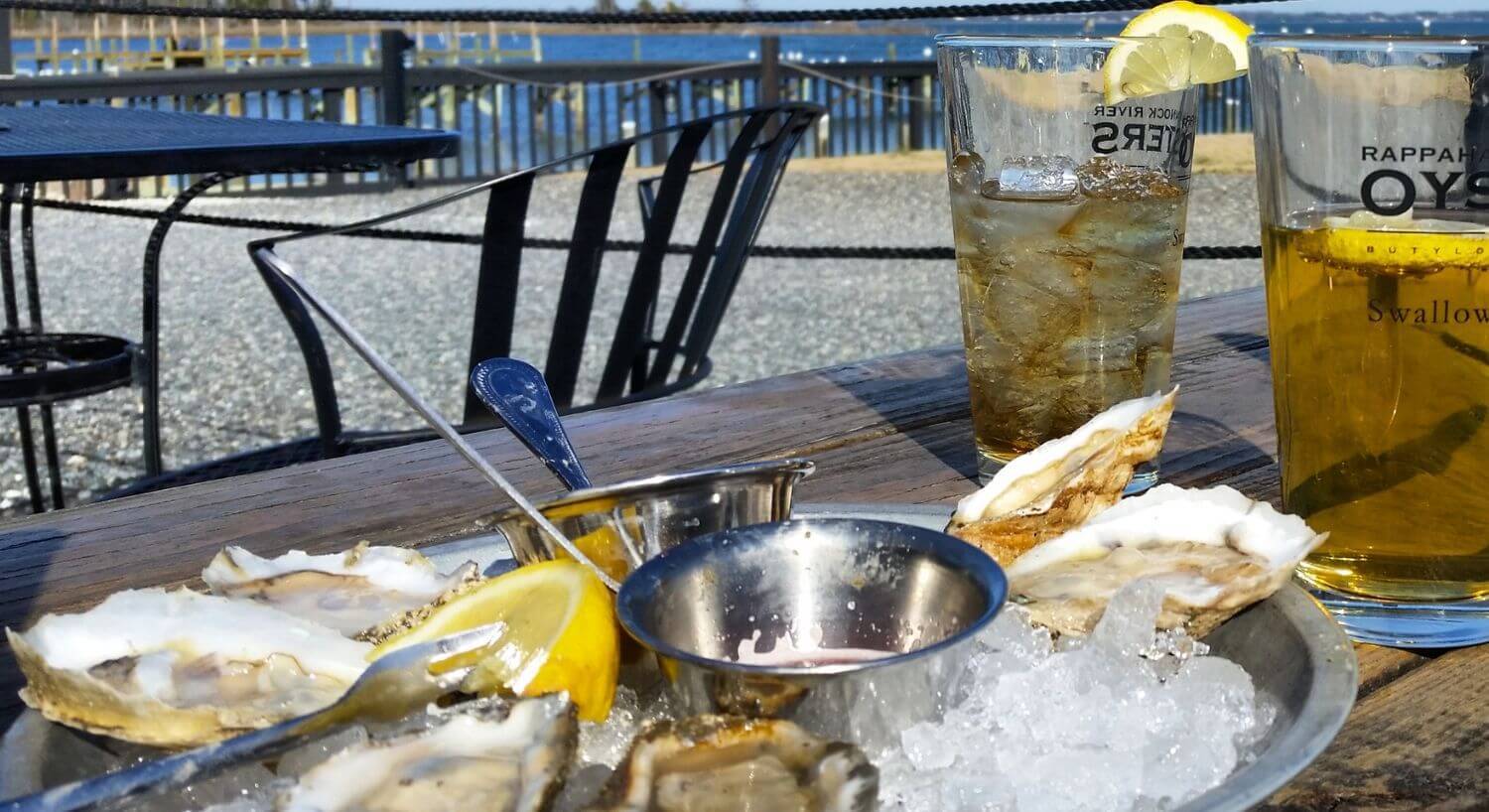 Close up view of a tray of oysters on a wooden picnic table