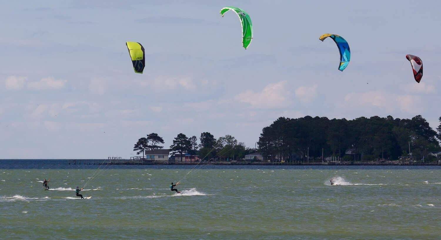 Multiple people kiteboarding on the water